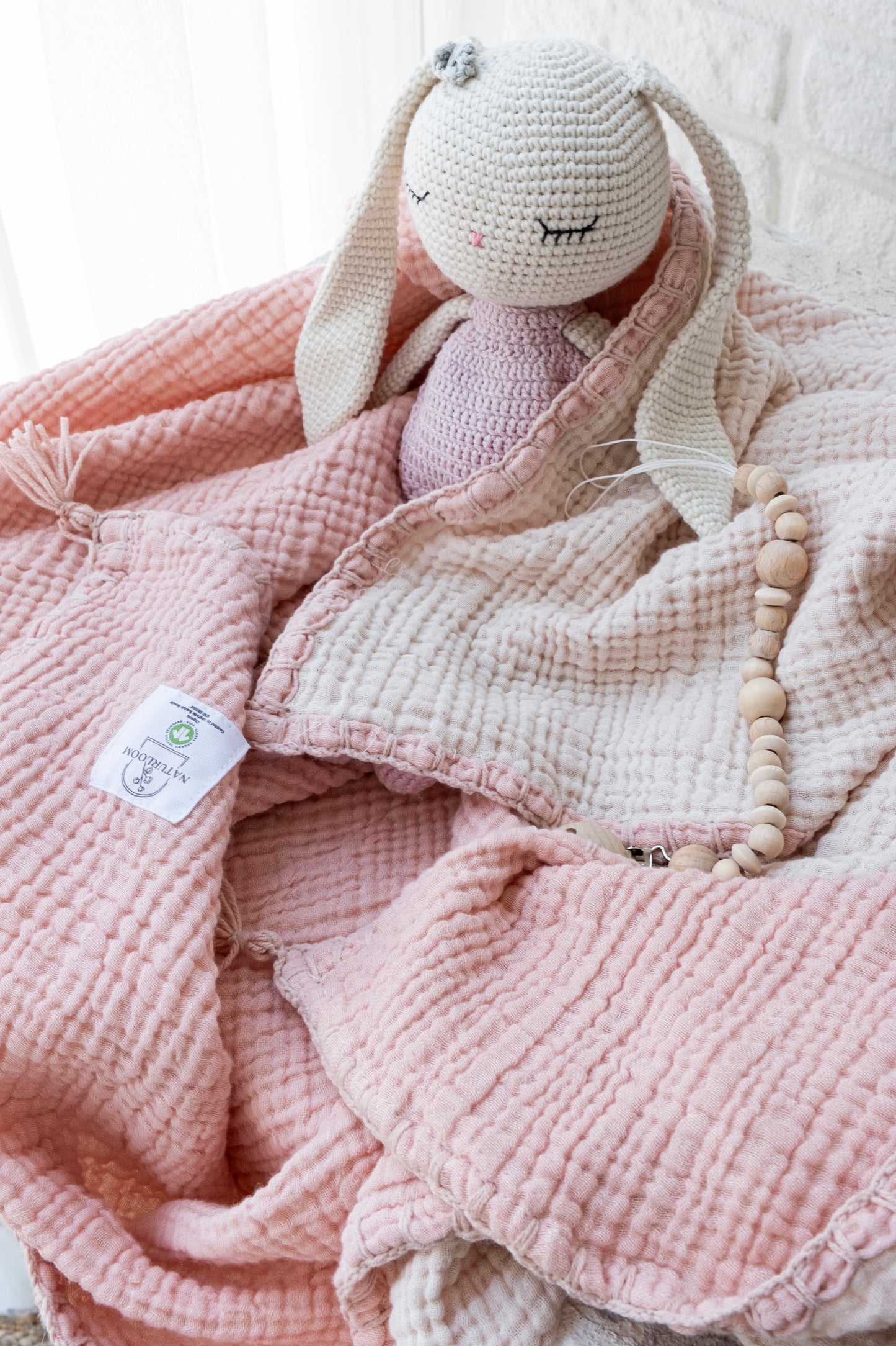 Pink organic muslin swaddle for nursery