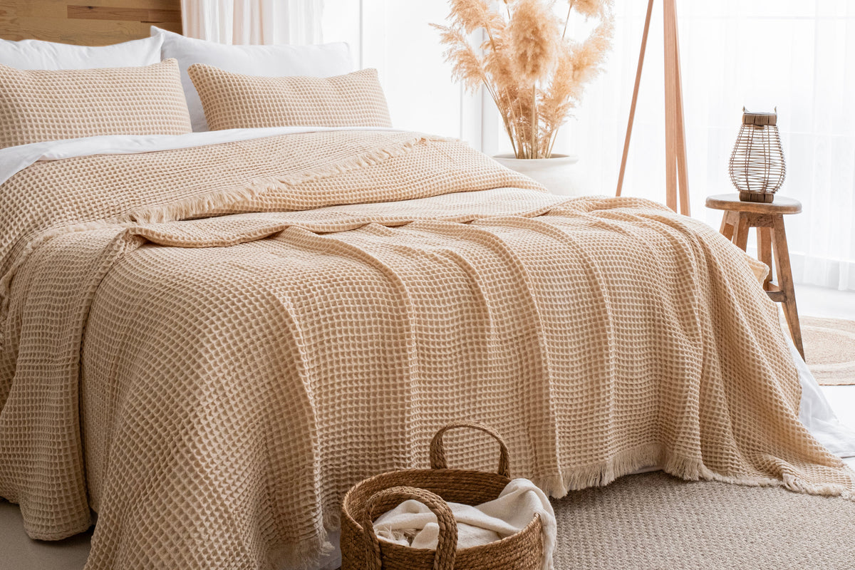 beige Naturloom cotton waffle blanket arranged on a bed