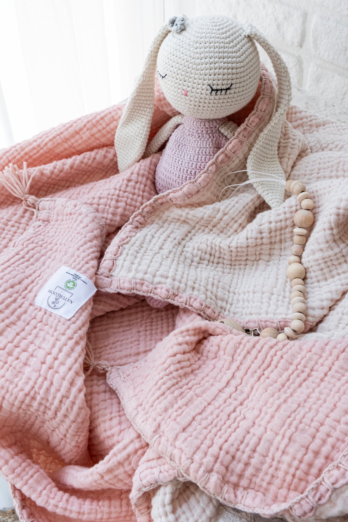 Pink organic muslin swaddle for nursery